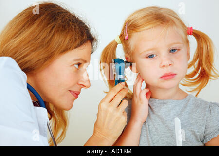 Pediatrician doctor examining little girl`s ears. Stock Photo